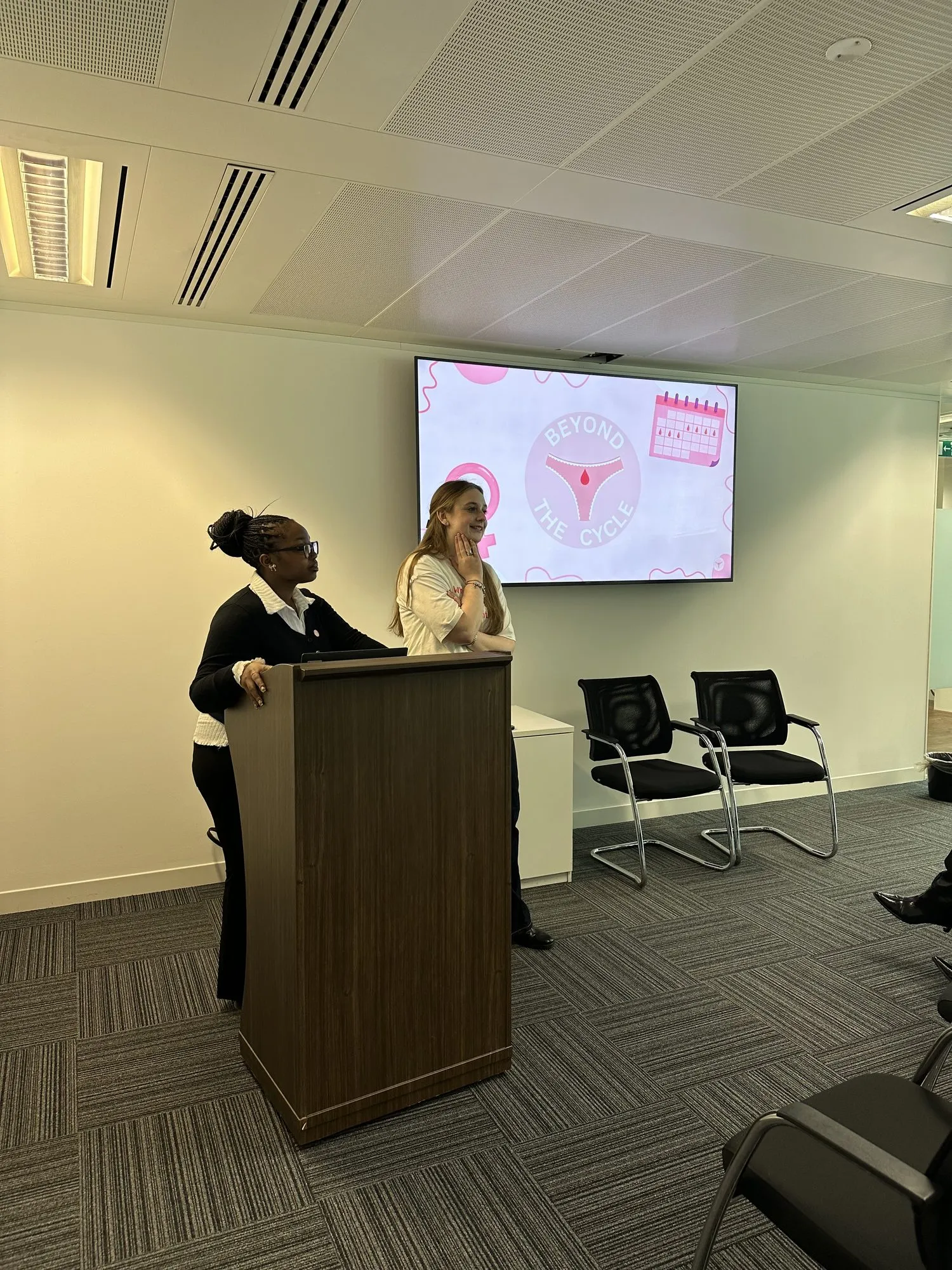 Beyond the Cycle team giving a talk from a podium at a corporate event