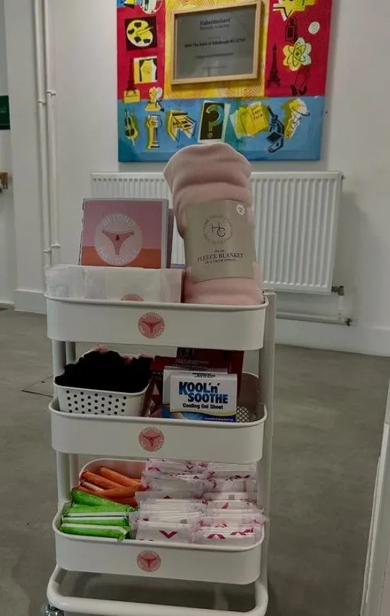 A Beyond the Cycle resource trolley stocked with period products, heat pads and a blanket
